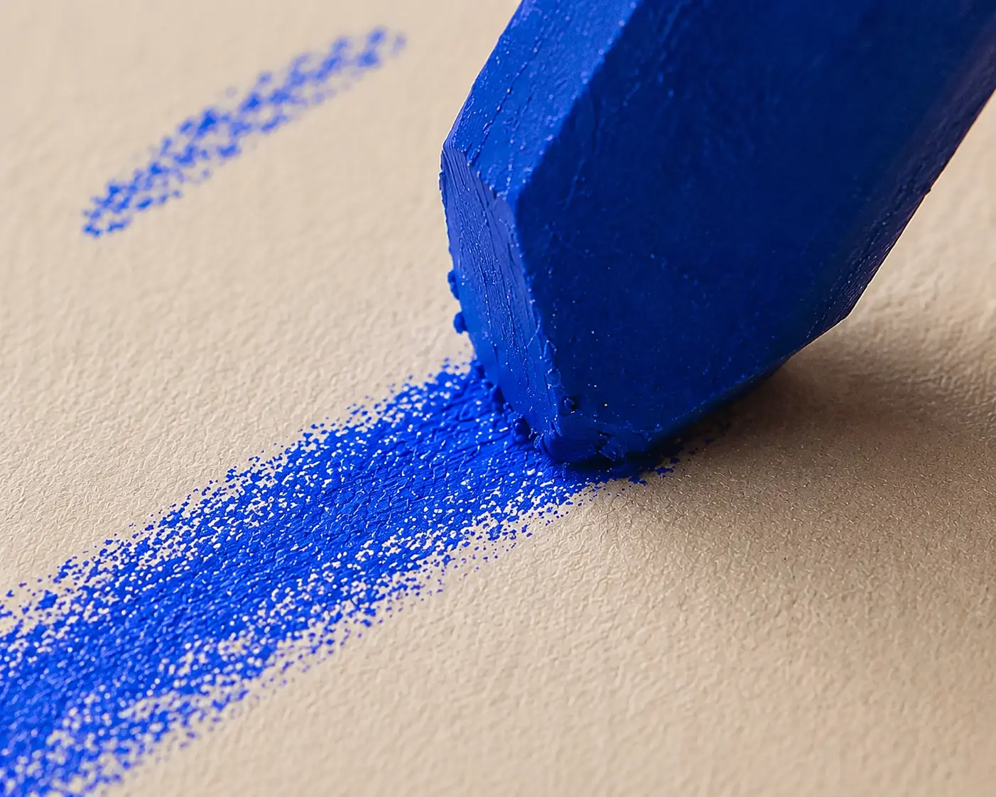 Macrofotografia da ponta de um giz azul-cobalto riscando o papel